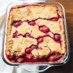 4 Ingredient Strawberry Dump Cake Close-up of golden crust with bubbling red filling in a glass pan